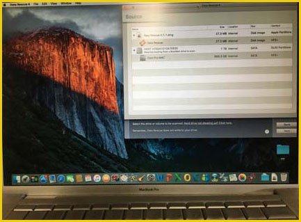 A technician at a Palm Coast Apple computer repair shop works on a Mac computer to backup and recover data using specialized software. The image shows the computer screen displaying the data recovery process