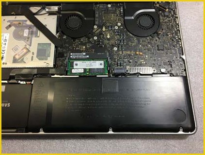 An image of an opened Apple Mac computer with the fan exposed, and a technician preparing to replace it, representing fan repair and replacement services offered at our Palm Coast Apple computer repair shop.