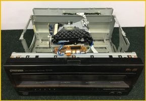 A Pioneer CD changer, a component of a Hi-Fi system, sits on a shelf in a repair shop.